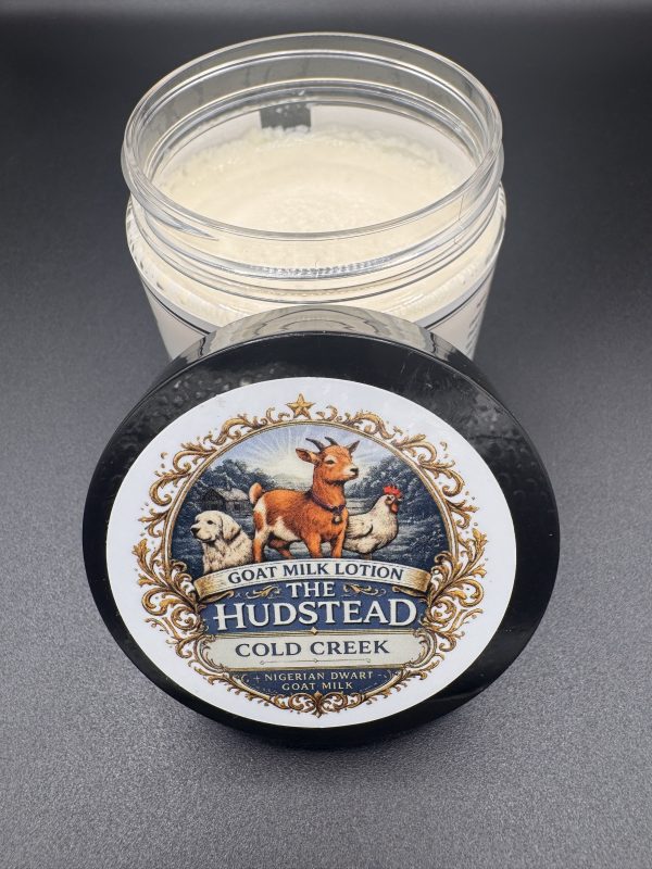 The Hudstead Cold Creek goat milk lotion jar opened to show the thick white cream inside